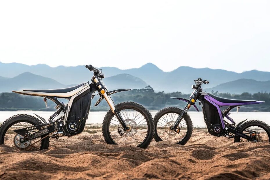 Duas motos elétricas off road 79BIKE na areia, com montanhas ao fundo