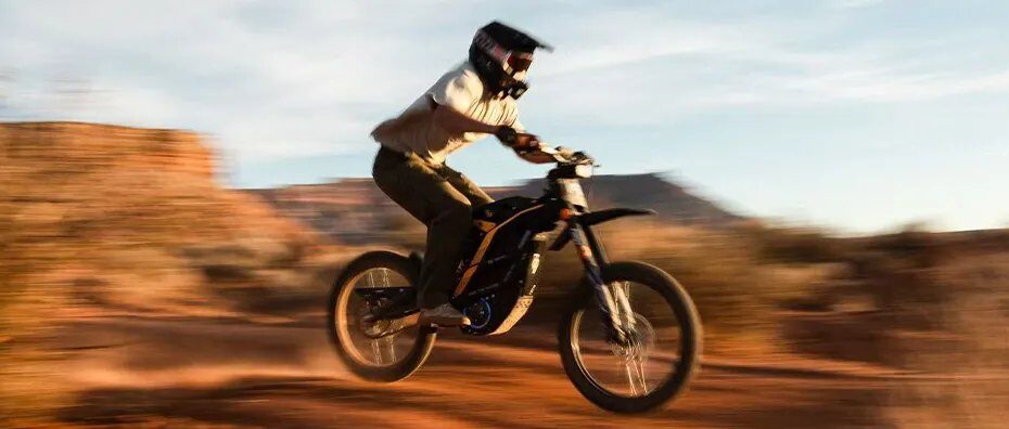 Piloto em moto elétrica off road 79BIKE numa trilha de terra